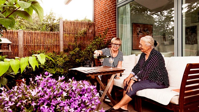 Mor og datter sidder på en terrasse.