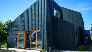 Nybygget hus i træ med brændt træ på facaden