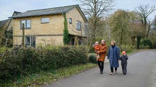 Familie går på vej foran hus