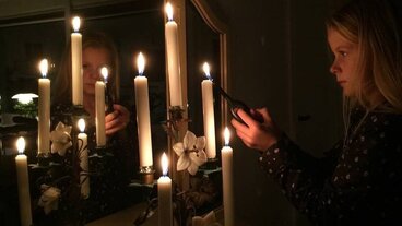 Pige tænder flere stearinlys