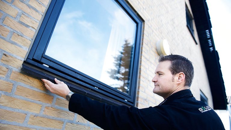 Mand undersøger vindue med aluminiumskappe