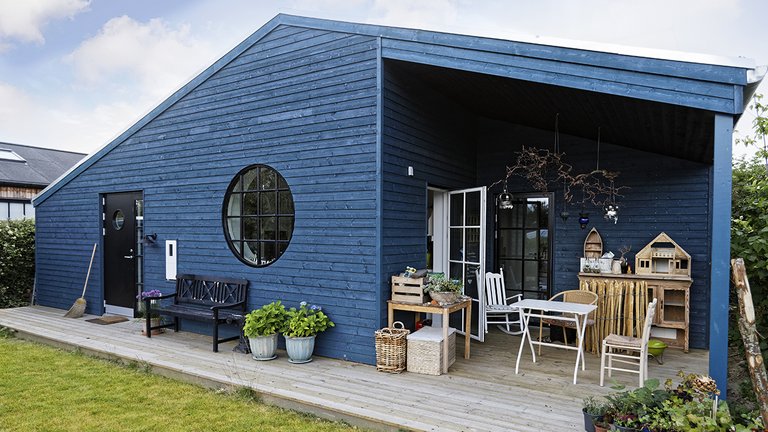 Blåt træhus minder om et sommerhus
