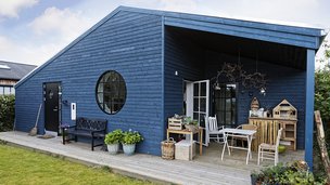 Blåt træhus minder om et sommerhus