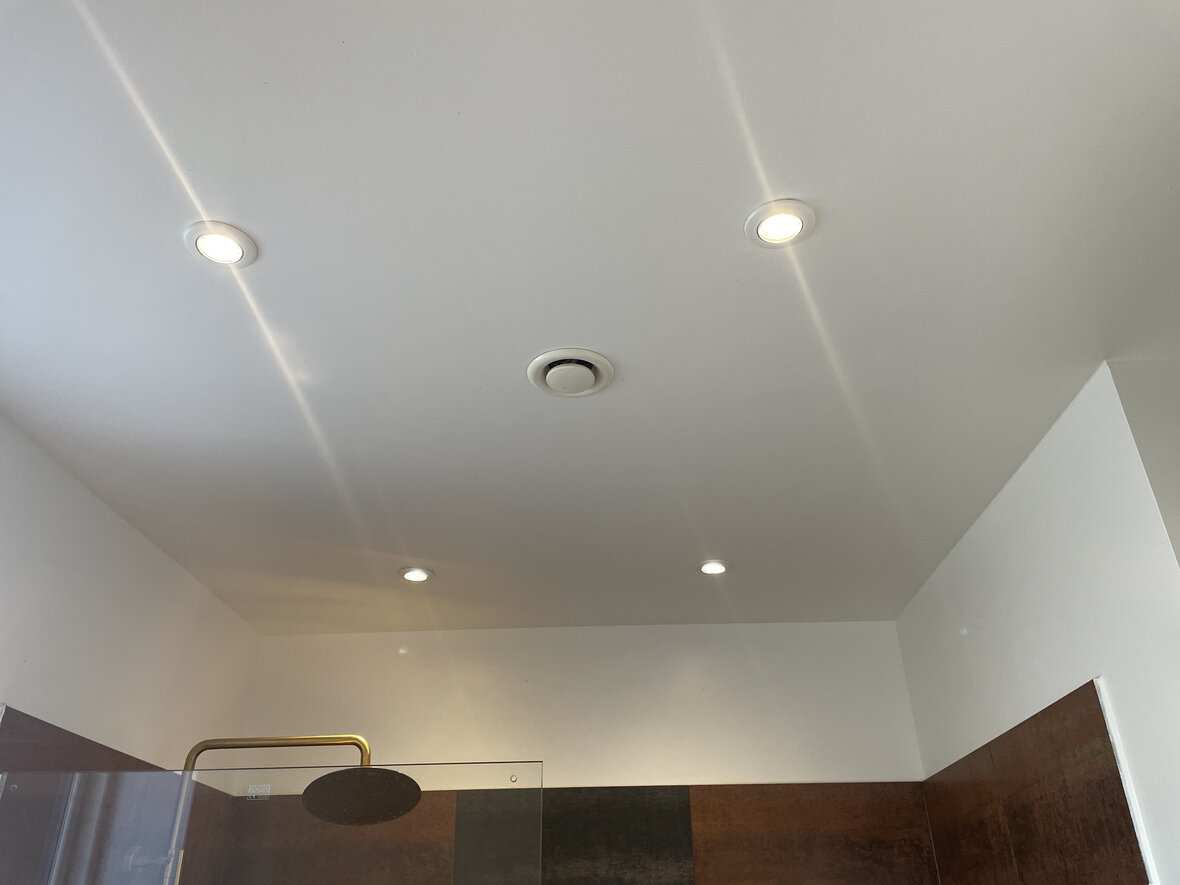 Mekanisk ventilator i loft over brusebade på badeværelse