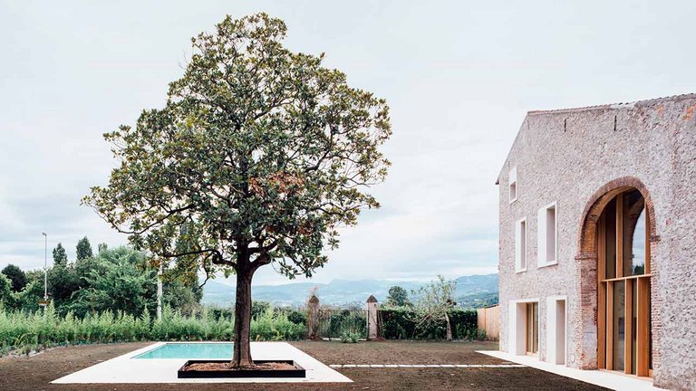 : Ombygget italiensk lade ved Verona med magnolietræ foran swimmingpool