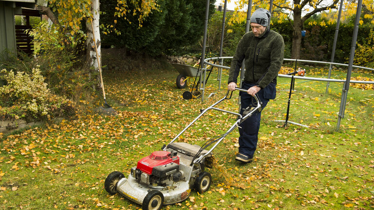 mand slår græs for sidste gang i efteråret