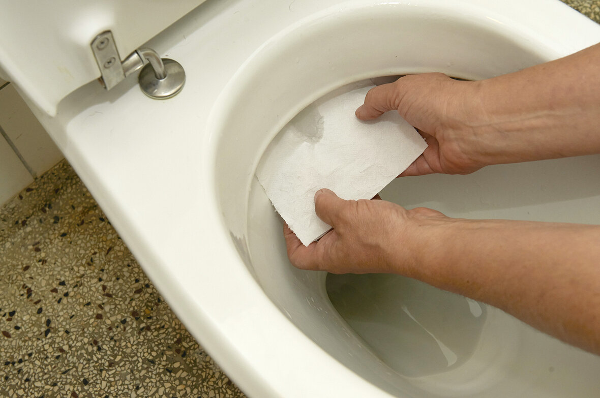 Toiletpapir sættes fast i toilet