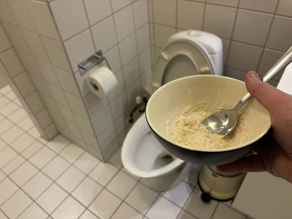grød af eddike og mel i skål med toilet i baggrunden