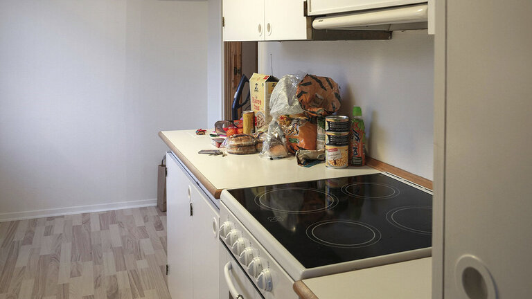Køkken med varer på bordet, et komfur og en emhætte