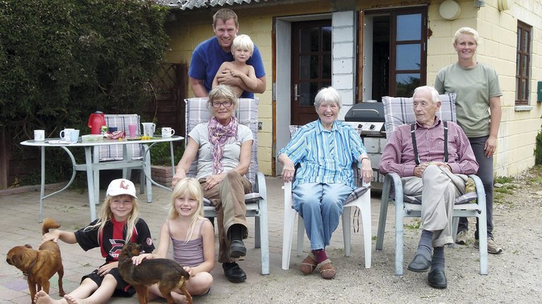 Familie i flere generationer foran hus