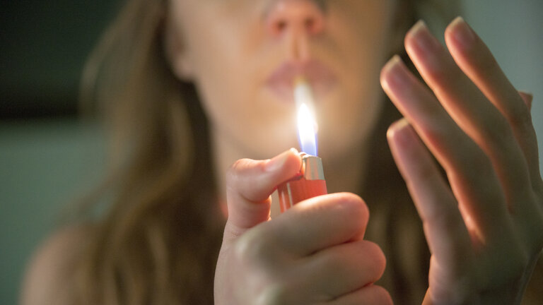 kvinder tænder cigaret indenfor med lighter