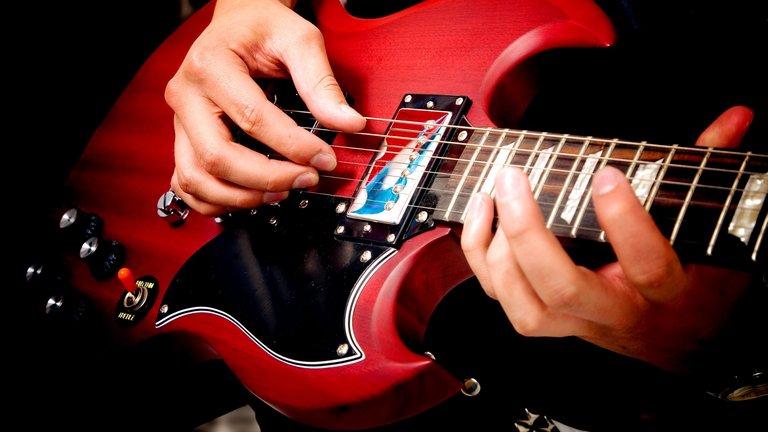 teenager larmer - spiller elguitar på værelset