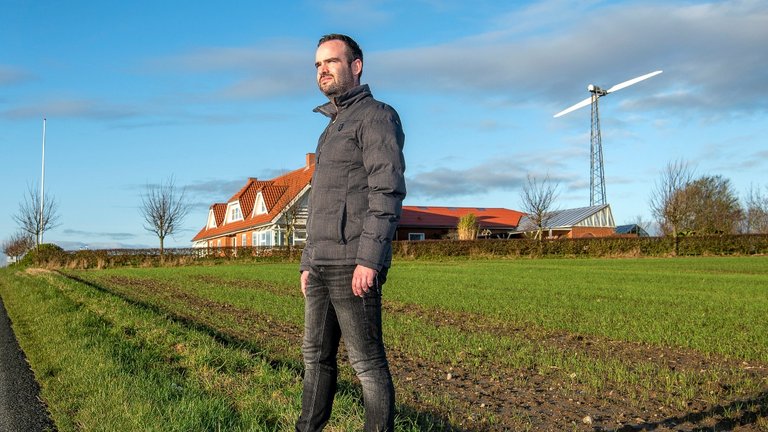 Mark Steiniche foran sit hus med vindmølle