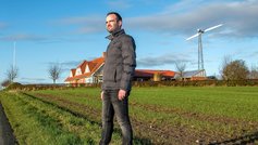 Mark Steiniche foran sit hus med vindmølle