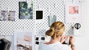 : Kvinde hænger ting op på hulplade