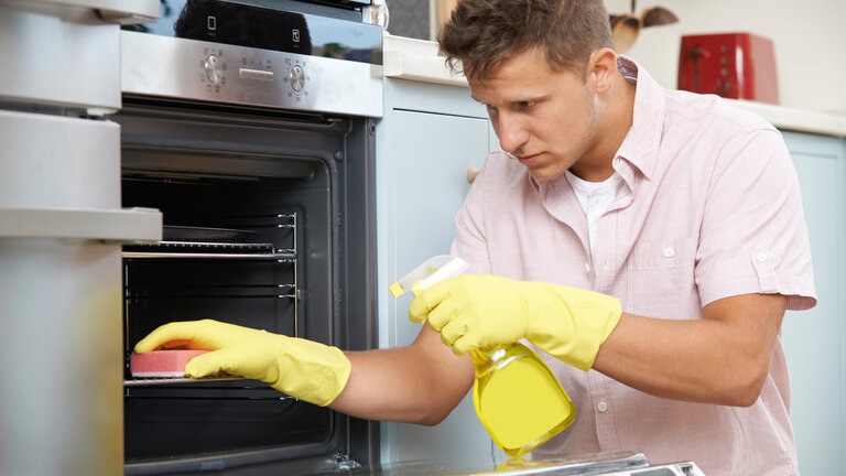 Mad koger i gryder på komfur uden låg og tændt emhætte