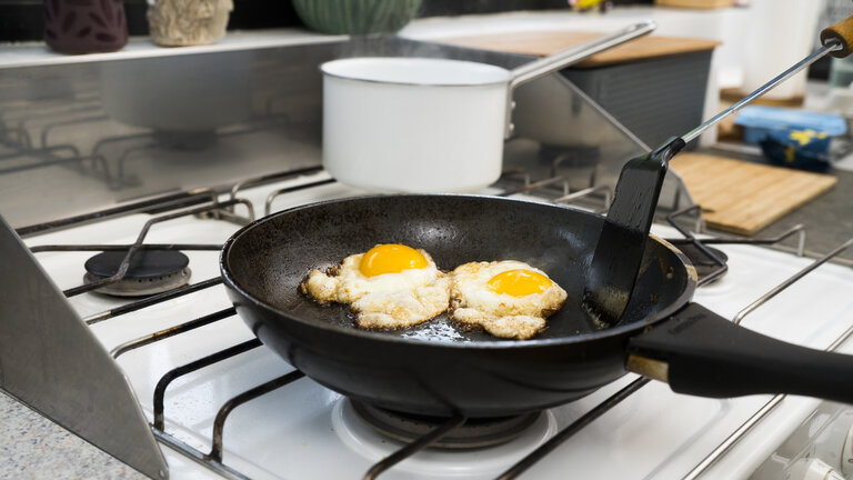 spejlæg på pande og gryde i kog på gaskomfur