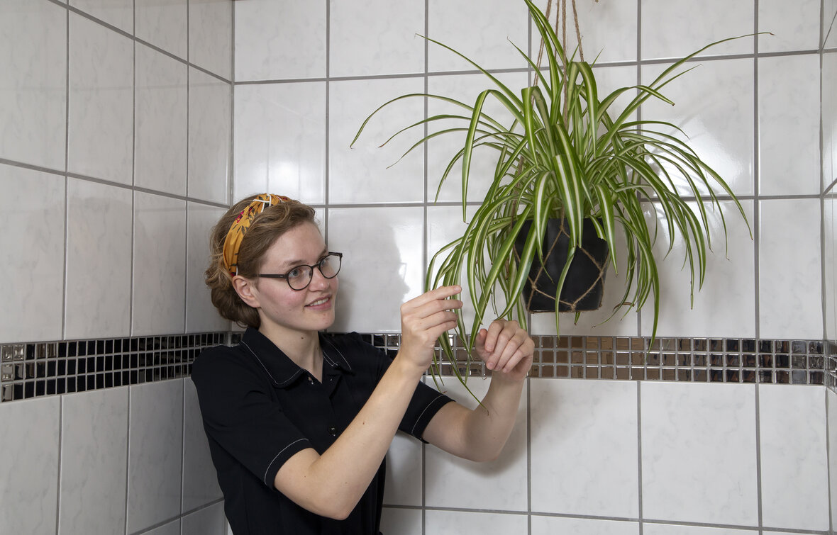 Mathilde Christensen, en af plantepigerne, ved plante på badeværelse.