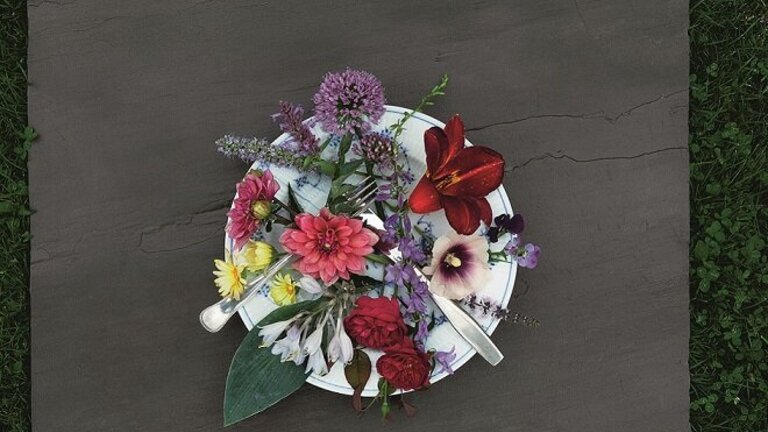 Spiselige blomster fra haven serveret på en tallerken