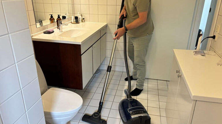 Mand støvsuger badeværelse