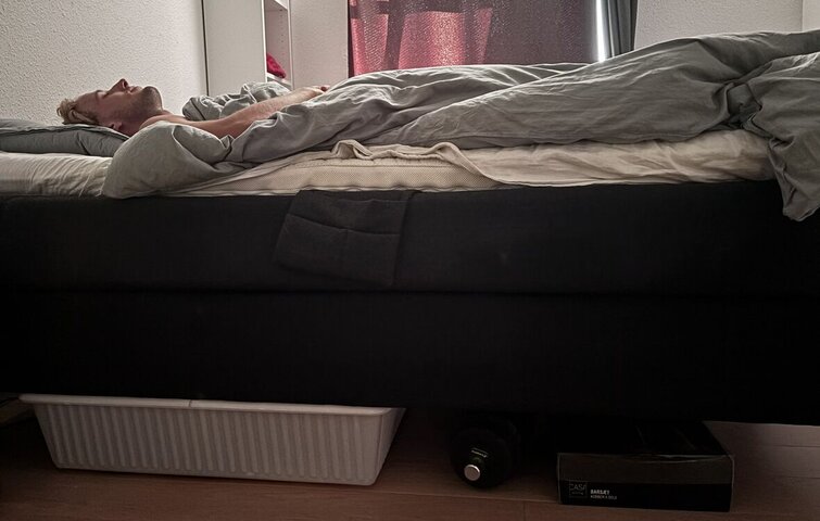 mand sover med ting under sengen i soveværelse