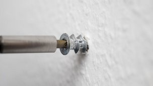 Skrue skrues ind i gipsvæg, så den fx kan holde et billede