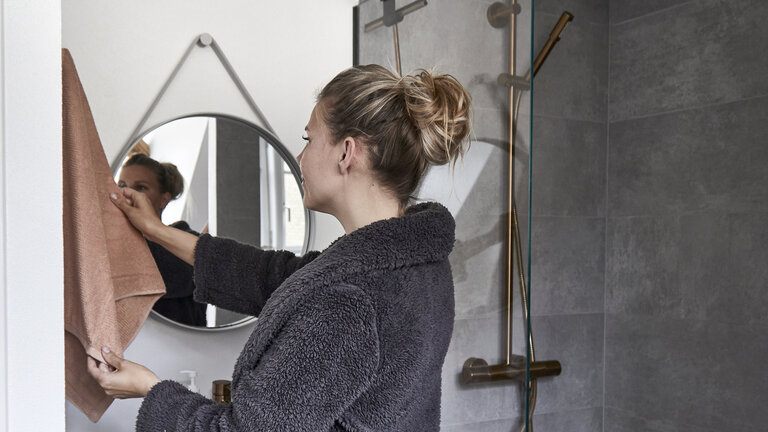 nyt badeværelse med rundt spejl og armatur i messing