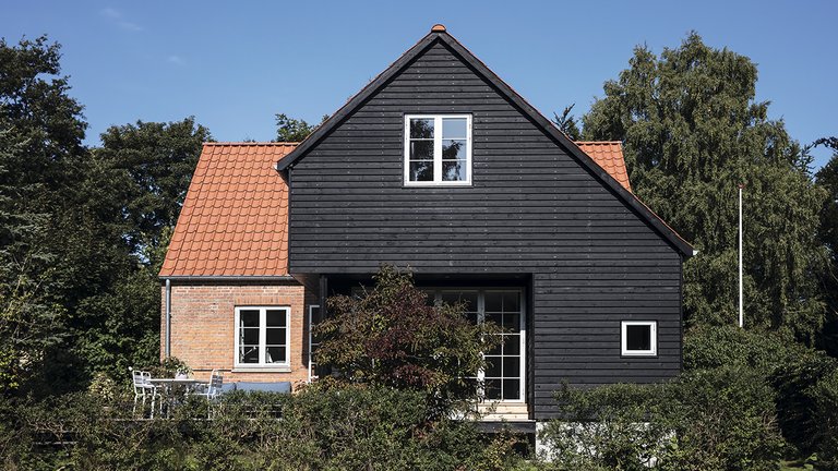 Statslånshus fra 1949 med moderne og sort tilbygning i træ