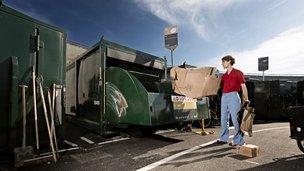 Mand smider pap i container