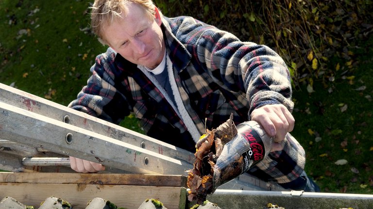 Mand renser tagrende med overskåret colaflaske