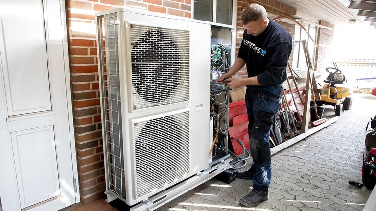 Installatør installerer ny varmepumpe i hus