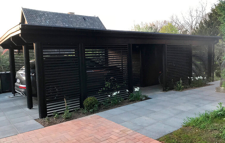 Carport med sorte lameller og runde stolper